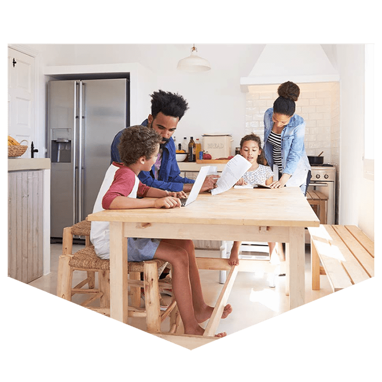 A family around a kitchen table discussing affordable mortgage options together. 