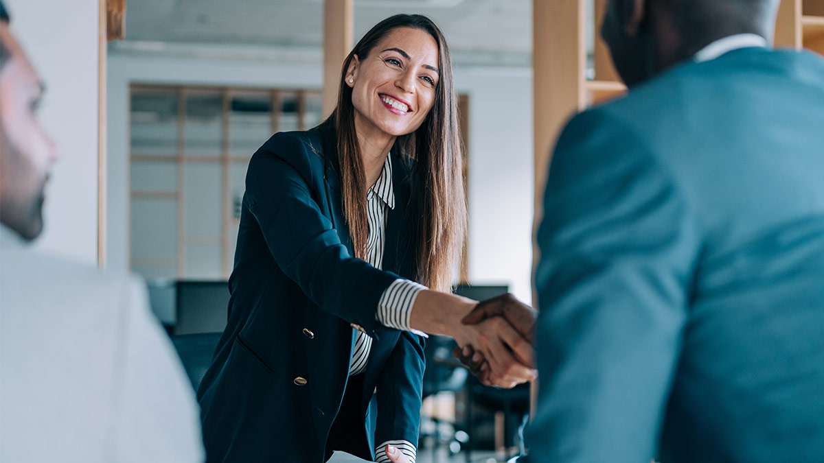 Photo of a business woman shaking hand during meeting
